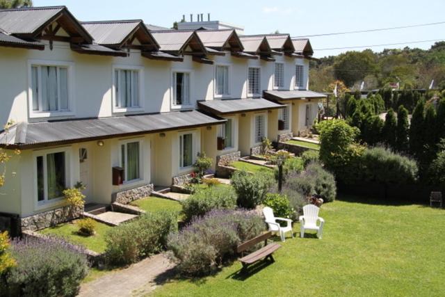 a row of houses with a yard with benches and flowers at Valeria Cielo in Valeria del Mar