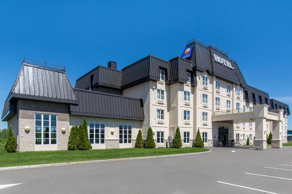 un grand bâtiment blanc avec un toit noir dans l'établissement Comfort Inn & Suites Levis / Rive Sud Quebec city, à Lévis