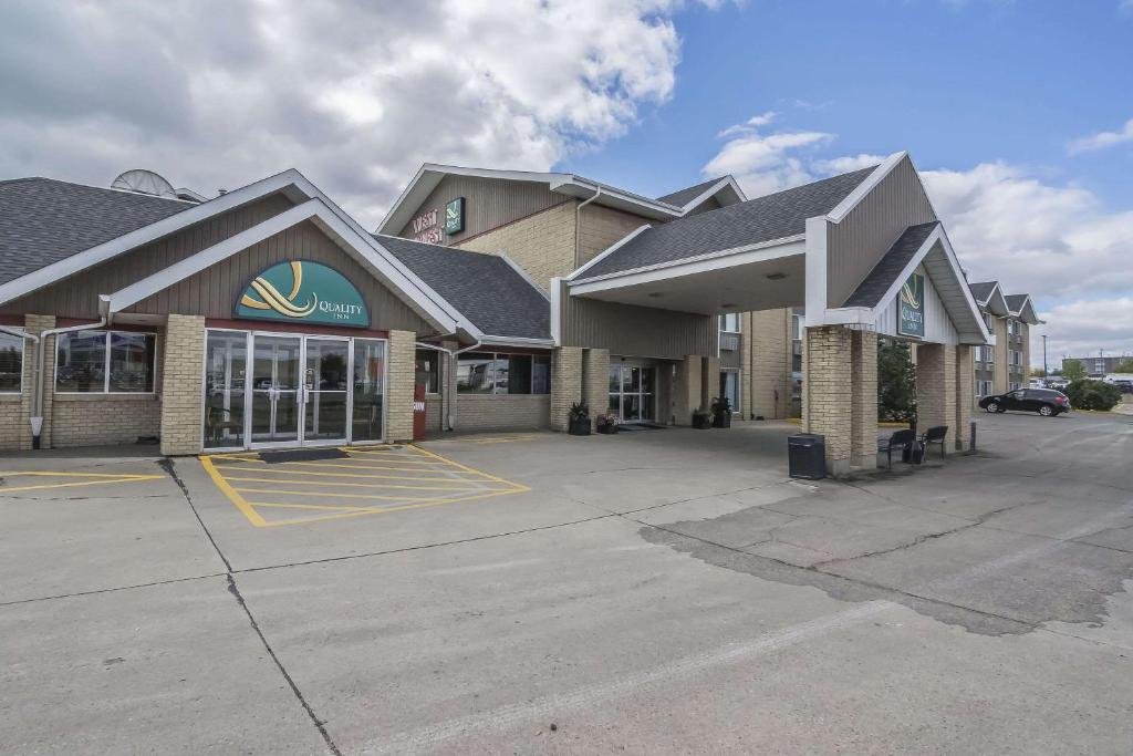 a store with a parking lot in front of it at Quality Inn West Edmonton in Edmonton