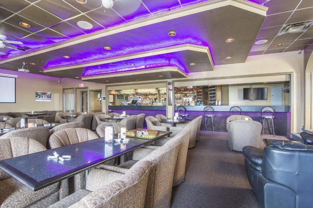 un restaurante con techos morados, mesas y sillas en Quality Inn &amp; Suites High Level, en High Level