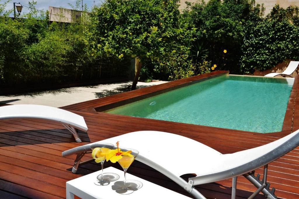 ソン・サルベーラにあるAmplia casa con piscina cerca playaのデッキ(スイミングプール、椅子2脚、テーブル付)