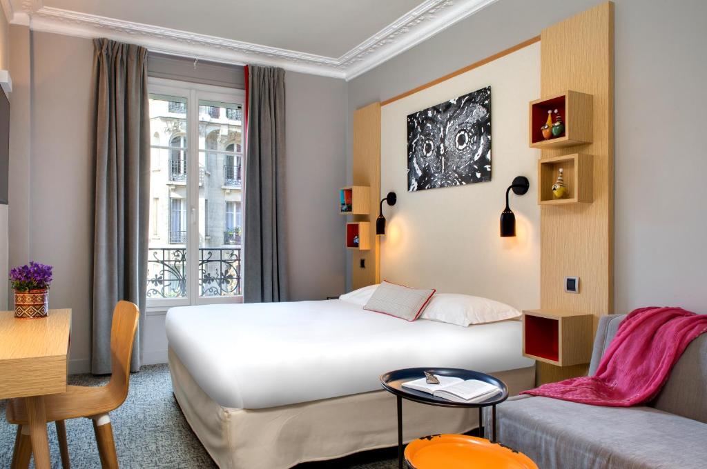 pokój hotelowy z łóżkiem i kanapą w obiekcie Chouette Hotel w Paryżu