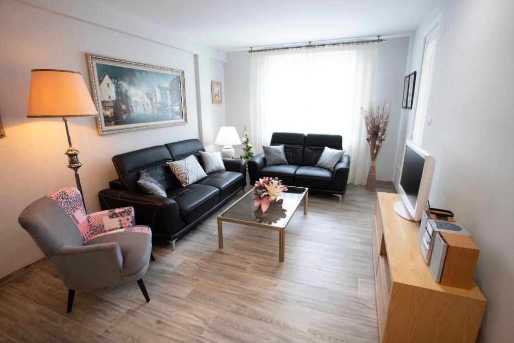 a living room with a black couch and a tv at La Mirada in Castellón de la Plana