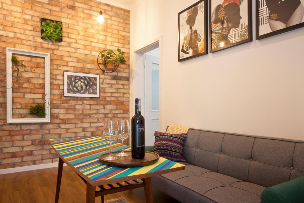 een woonkamer met een bank en een tafel met wijnglazen bij Szczecin Old Town Apartments - 2 Bedrooms Deluxe in Szczecin