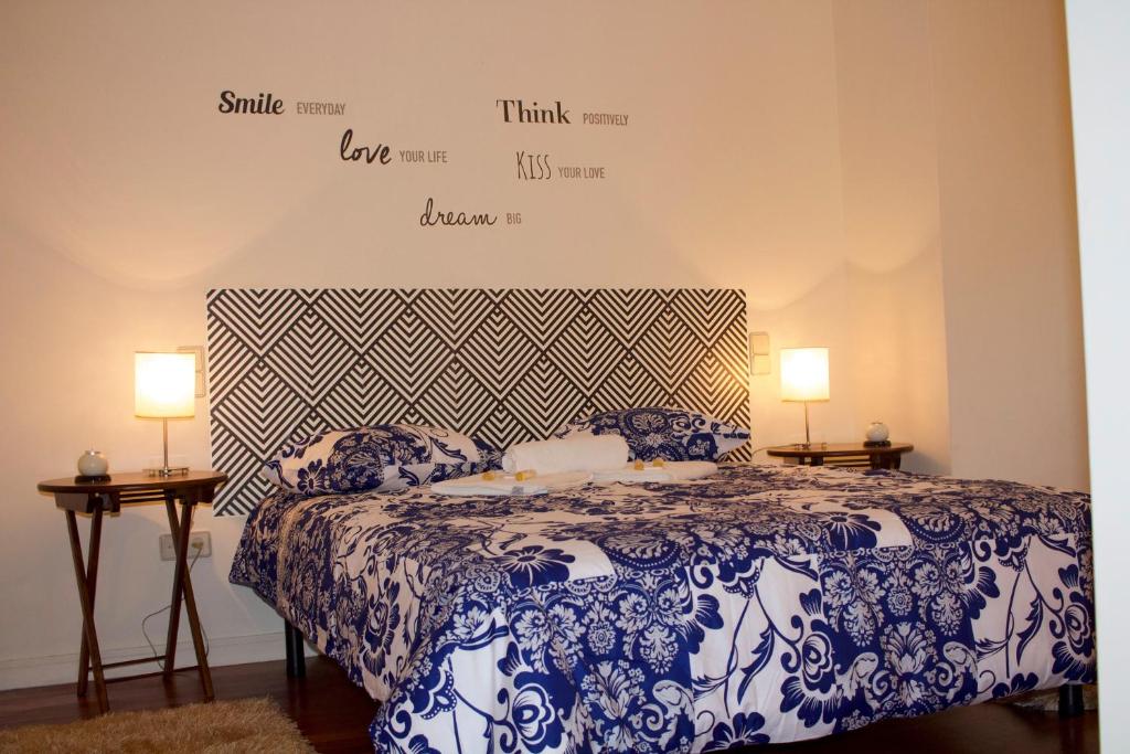 a bedroom with a blue and white bed with two lamps at Casino Figueira Prime Apartment in Figueira da Foz