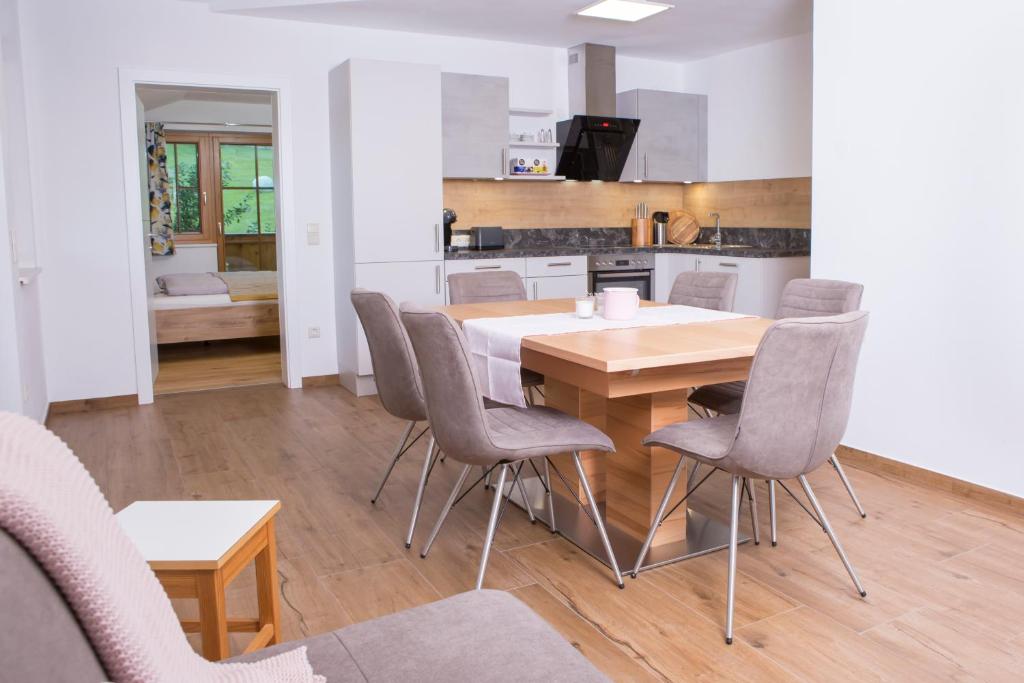 cocina y comedor con mesa de madera y sillas en Oberschartlhof, en Flachau