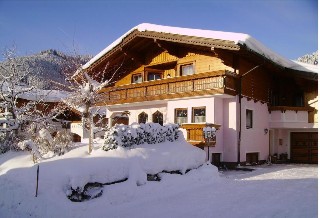 una casa coperta di neve davanti ad essa di Ferienwohnungen Haus Sonnenschein a Flachau