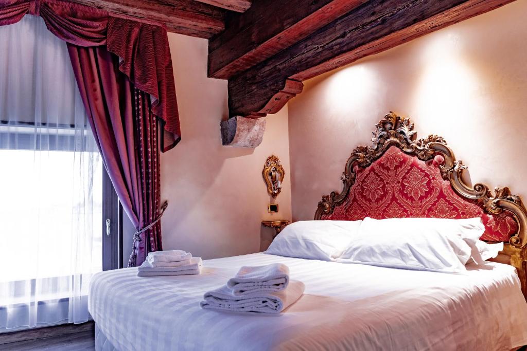 a bedroom with a large bed with towels on it at Hotel Vecellio Venice on the Lagoon in Venice