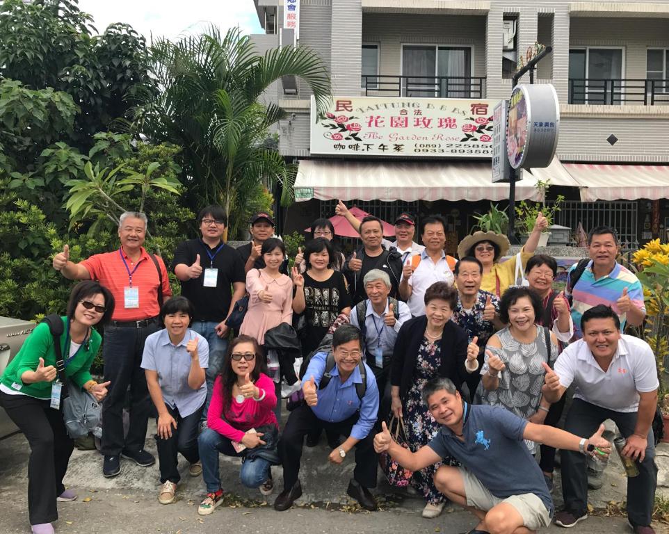 a group of people posing for a picture in front of a building at Garden Rose Homestay in Taitung City