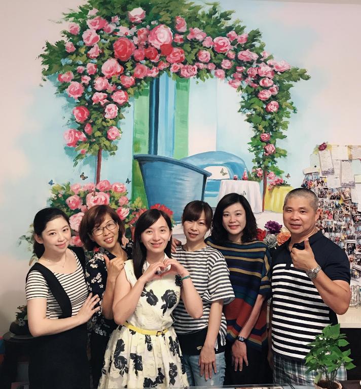 a group of people standing in front of a floral arch at Garden Rose Homestay in Taitung City