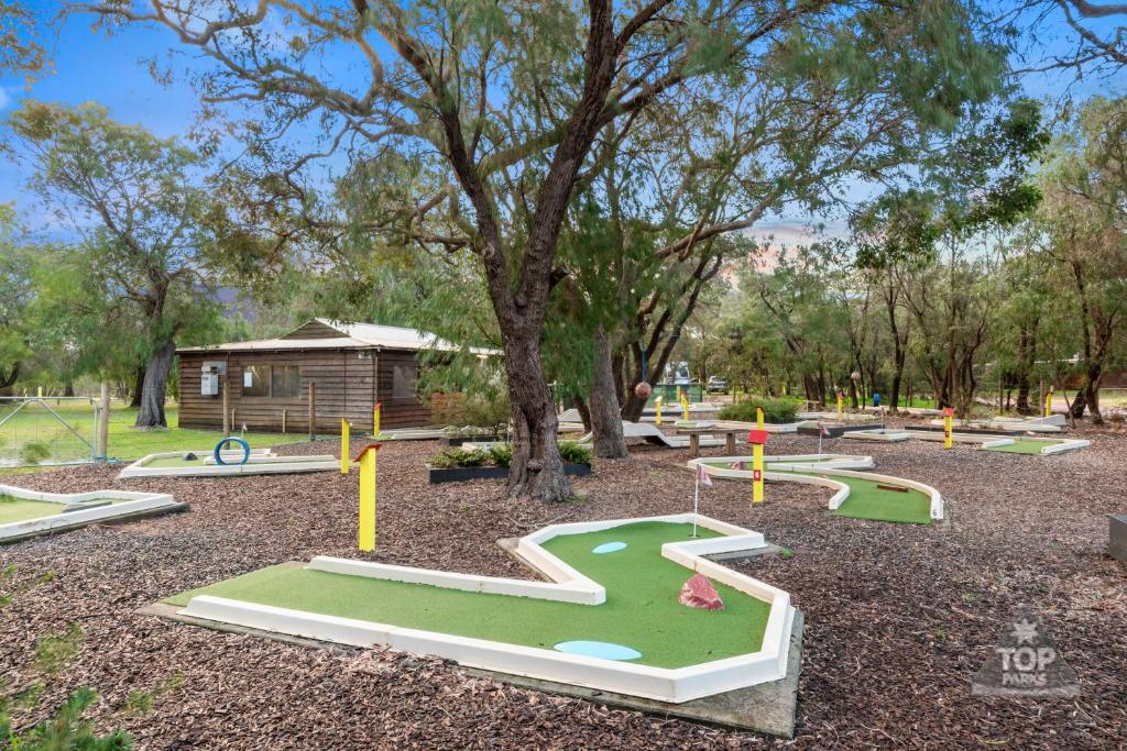 um parque infantil com um campo de golfe num parque em Gracetown Caravan Park em Gracetown