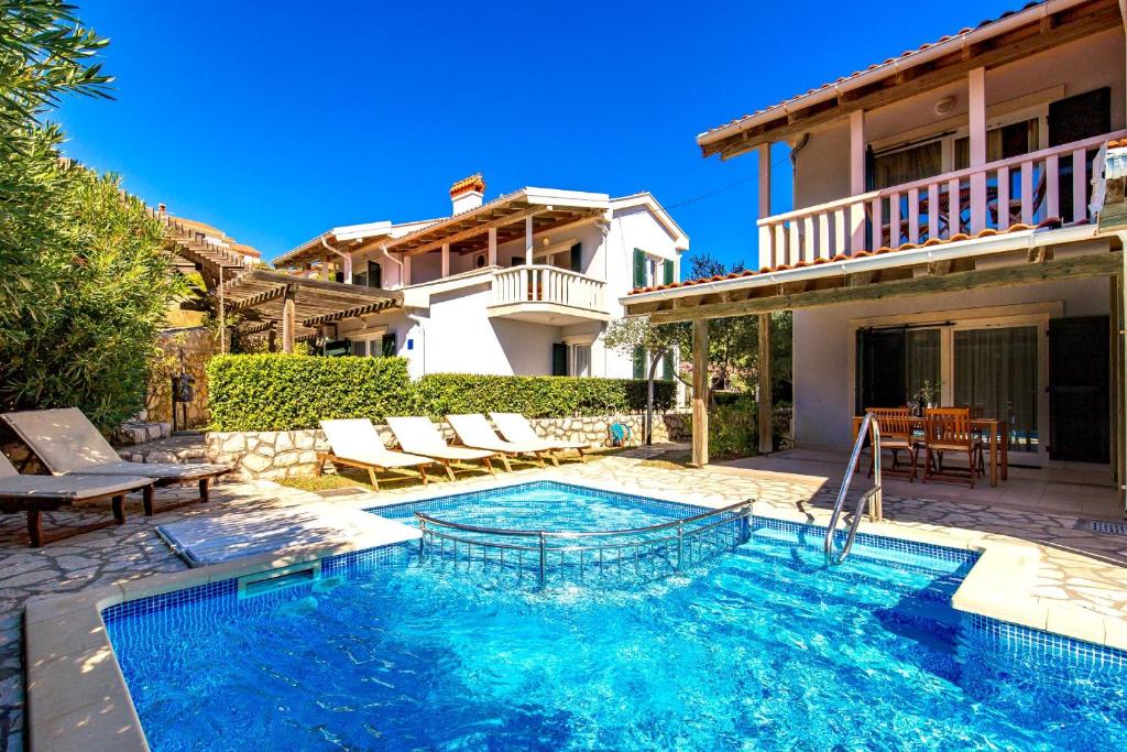 a swimming pool in the backyard of a house at Villas Rab Palit in Rab