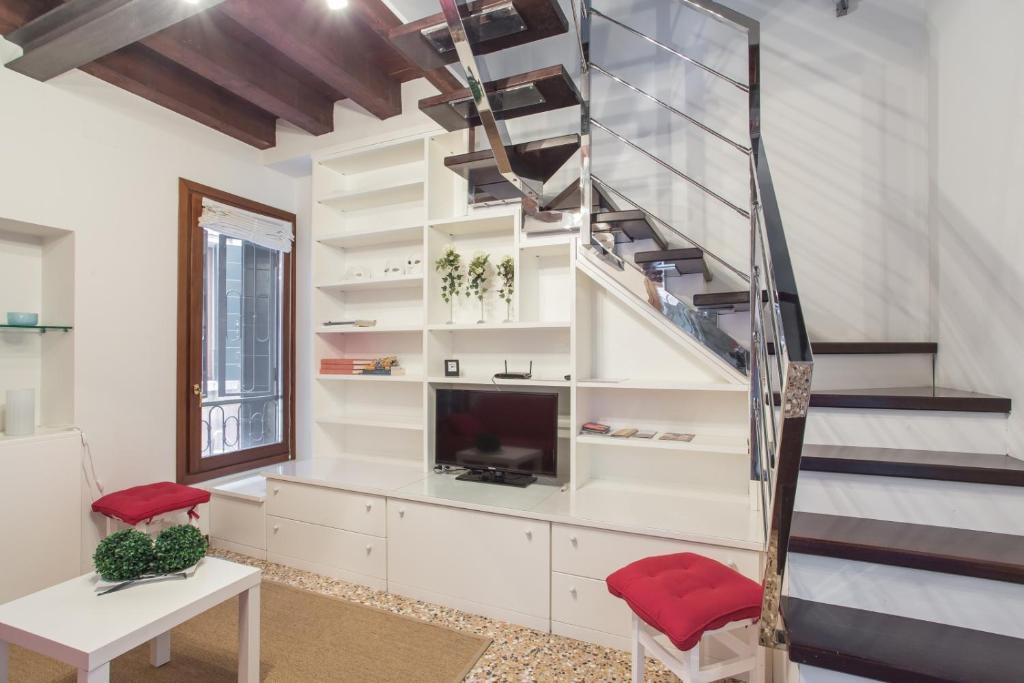 een woonkamer met een trap en een televisie bij Cà della Regina in Venetië