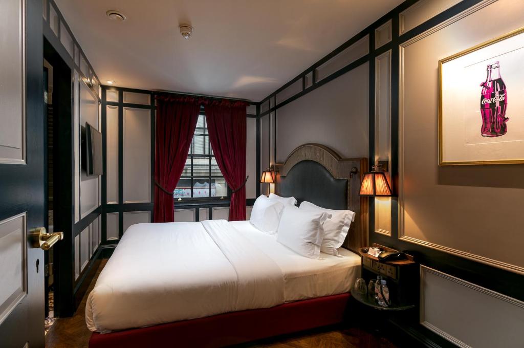 a hotel room with a bed and a window at Mimi's Hotel Soho in London