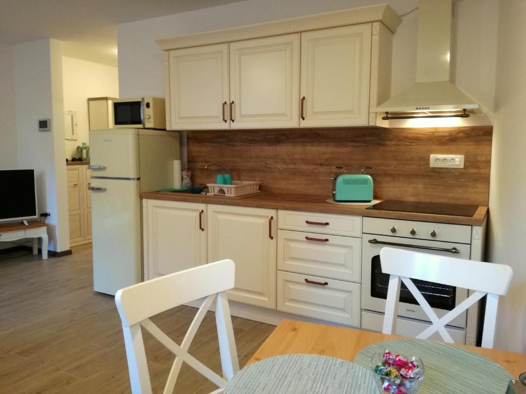 a kitchen with white cabinets and a table and chairs at Apartment Lunaja in Piran