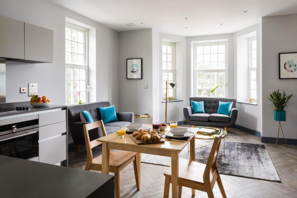 a kitchen and living room with a table and chairs at Farnborough Boutique by Viridian Apartments in Farnborough