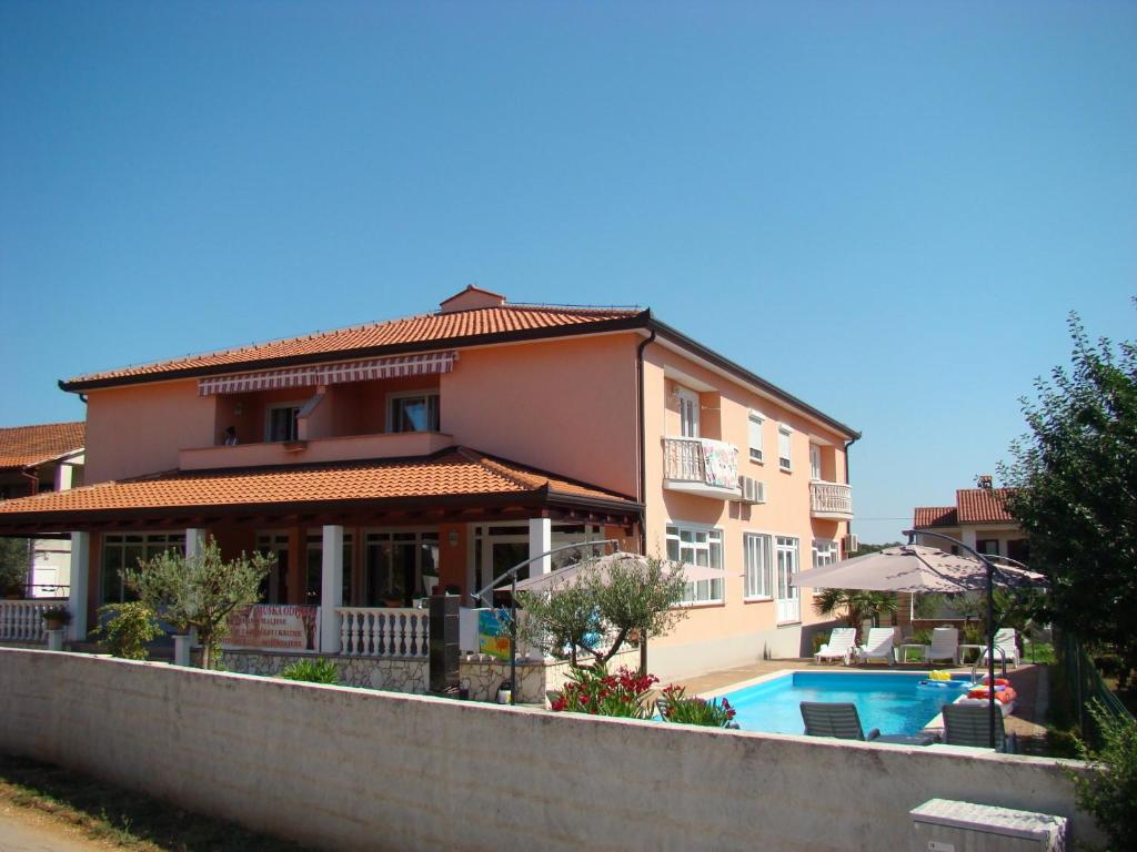 a house with a swimming pool in front of it at Apartments Kimm in Poreč