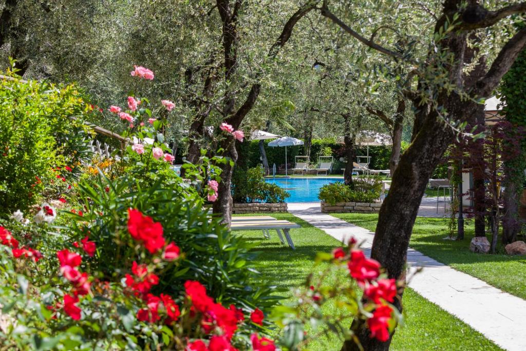 a park filled with lots of flowers and trees at Hotel Continental - TonelliHotels in Nago-Torbole