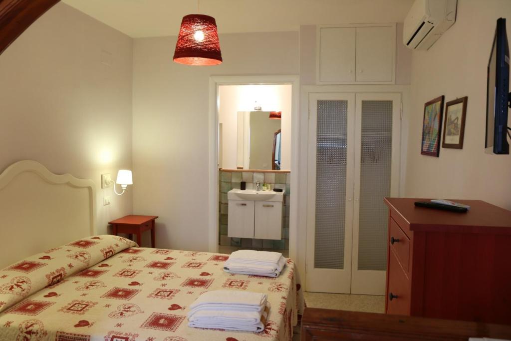 Casa Geo Sperlongaresort في سبرلونغا: غرفة نوم عليها سرير وفوط