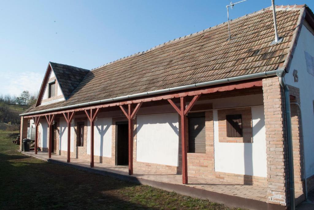 Kajászószentpéter的住宿－Szent Péter vendégház，白色门和棕色屋顶的建筑