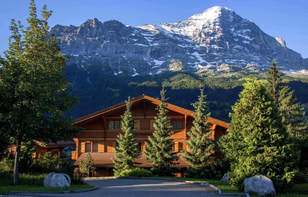 a log cabin with a mountain in the background at South in Grindelwald