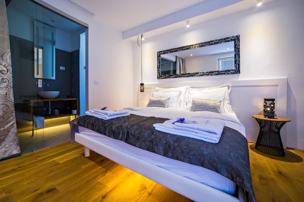 a bedroom with a large bed with a mirror on the wall at MEMENTO B&B Piran in Piran