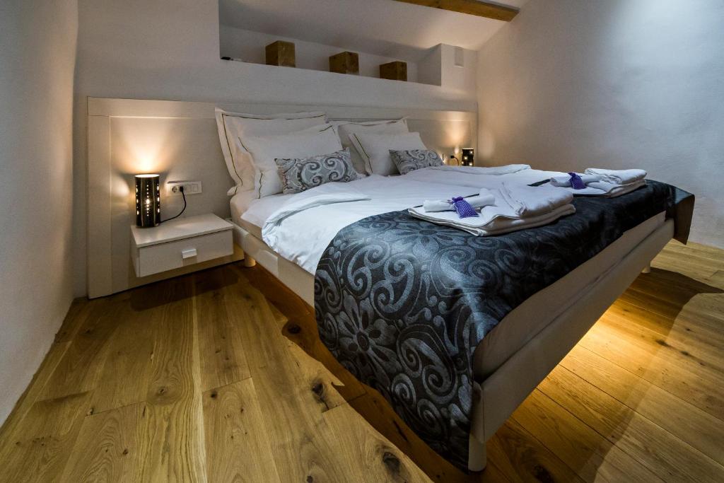 a bedroom with a large bed with white sheets at MEMENTO B&B Piran in Piran