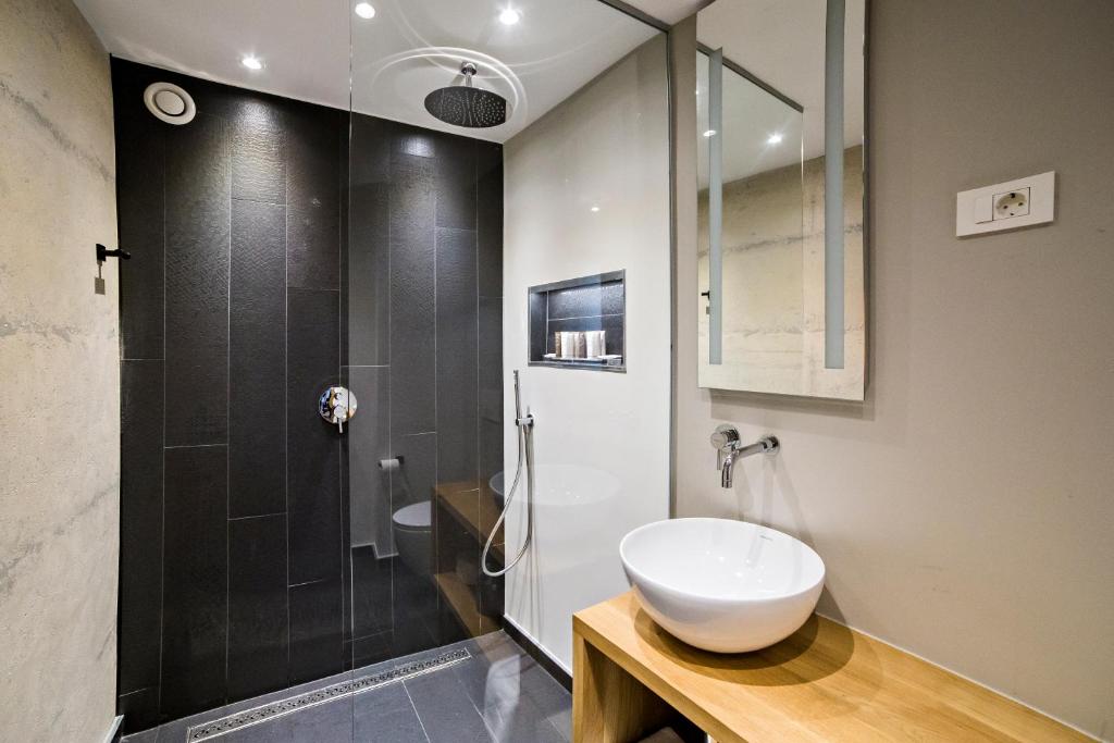 a bathroom with a shower and a white sink at MEMENTO B&B Piran in Piran