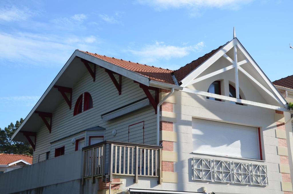 une maison avec un balcon et un toit dans l'établissement VILLA PLATA Appartement 2 Chambres Terrasse, à Arcachon
