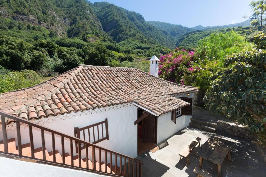 ラ・オロタバにあるFinca La Honduraの山を背景に屋根を持つ小さな白い家