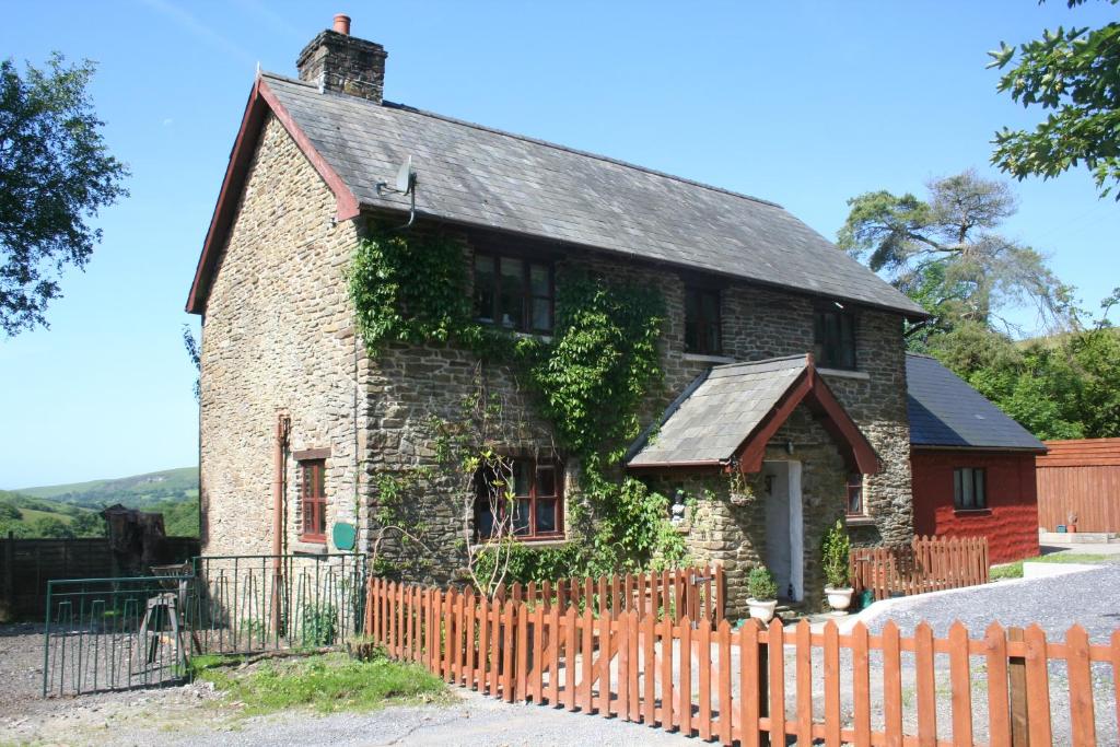 an old brick house with ivy on it at Barn Cottage - Farm Park Stay with Hot Tub in Swansea
