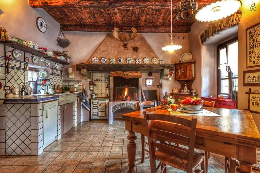 une grande cuisine avec une table en bois et une salle à manger dans l'établissement B&B Dove Comincia la Bella Italia, à Beura