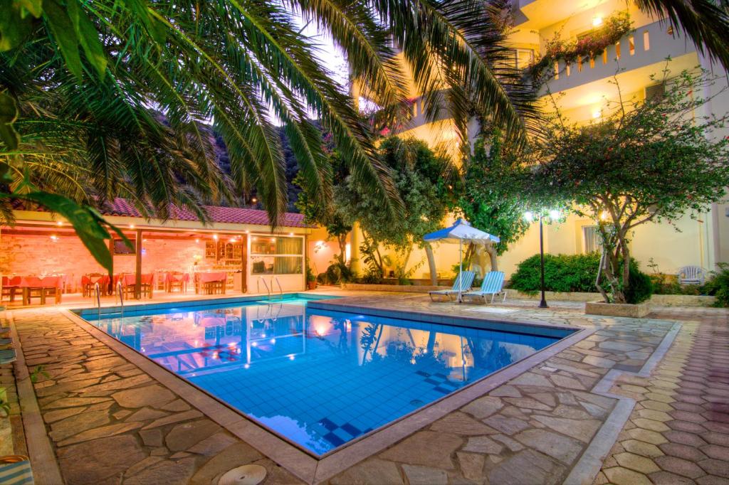una piscina di fronte a un edificio di Sunrise Hotel & Apartments a Rodakino