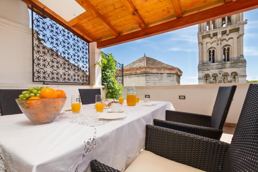a dining table with a bowl of fruit on a balcony at Penthouse Matkovic in Split