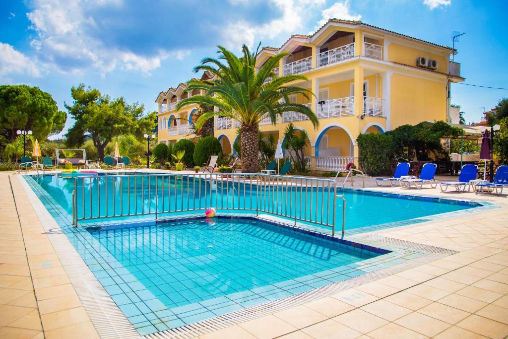 a large swimming pool in front of a building at Sunflower Apartments & Studios in Laganas