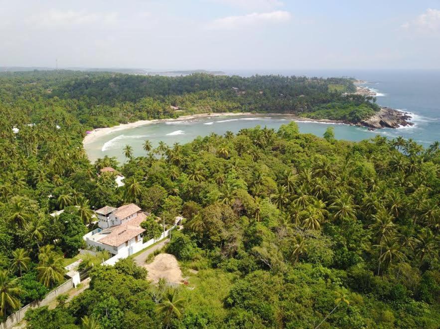 una vista aérea de una casa en una colina con una playa en Serene Villa en Hiriketiya