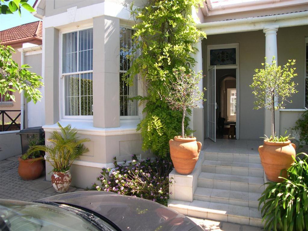 une maison avec des plantes en pot sur le porche dans l'établissement Werner Guest Room, au Cap