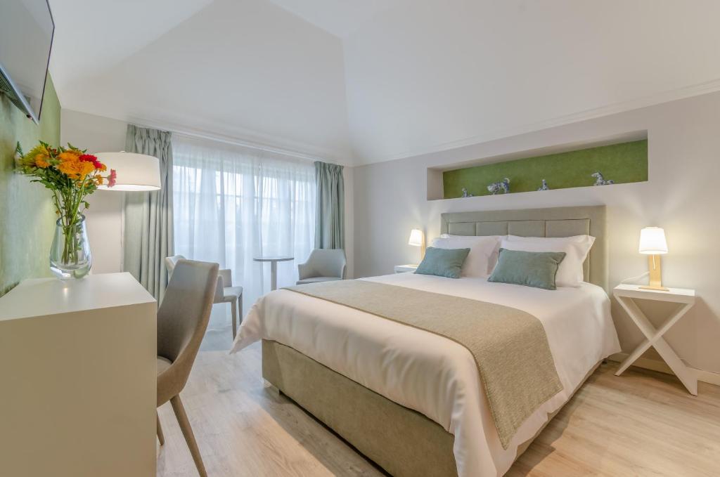 Ver Belém Suites في لشبونة: غرفة فندقية بسرير كبير وطاولة