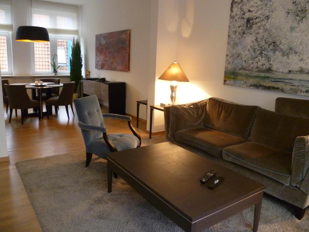 a living room with a couch and a table at Villa Greve - Deluxe Suite in Bad Salzuflen