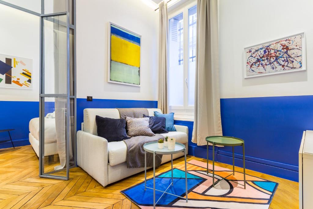 a living room with a couch and a table at CMG Iéna/ Serbie in Paris