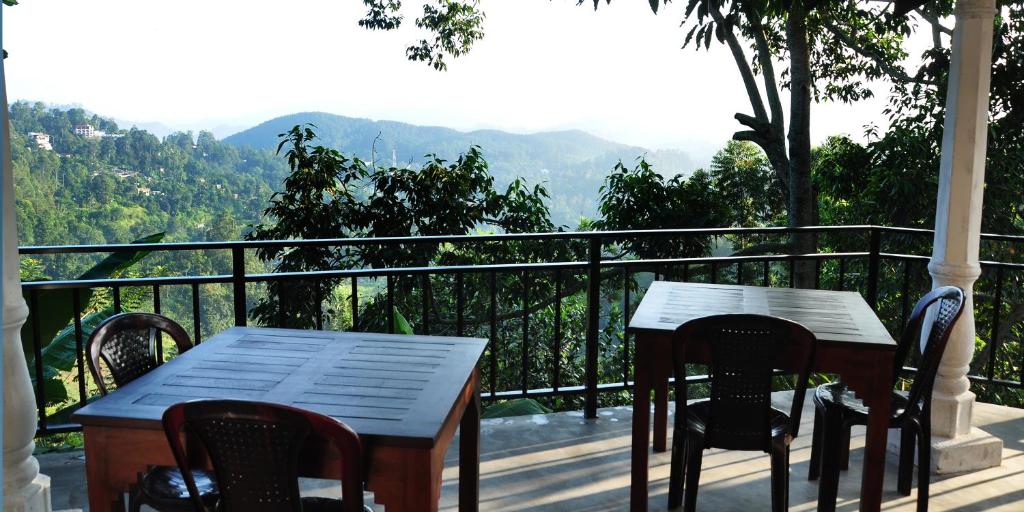 een tafel en stoelen op een balkon met uitzicht bij Okeed Ella in Ella