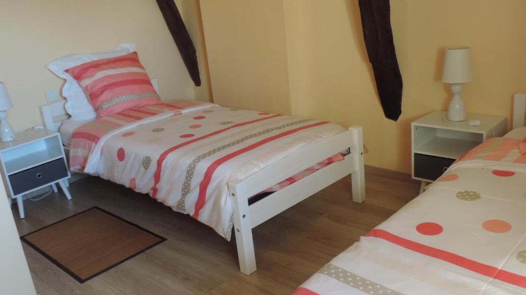 a small bedroom with two beds and a night stand at Le Mas de Cascabel in Causse et Diege