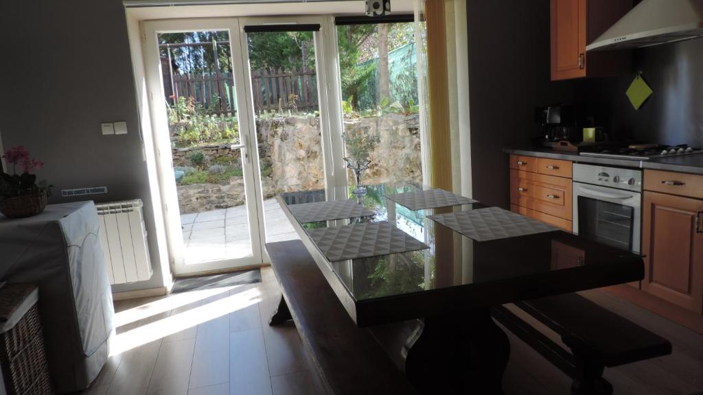 a kitchen with a glass table and an open door at Le Mas de Cascabel in Causse et Diege