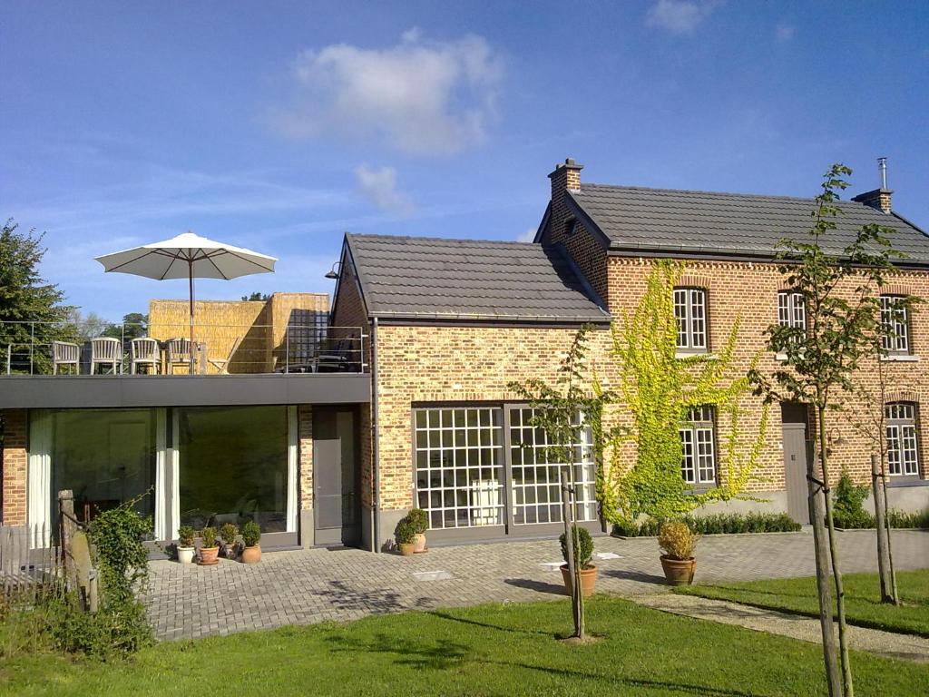 a brick house with an umbrella in front of it at De Waterkriek in Borgloon