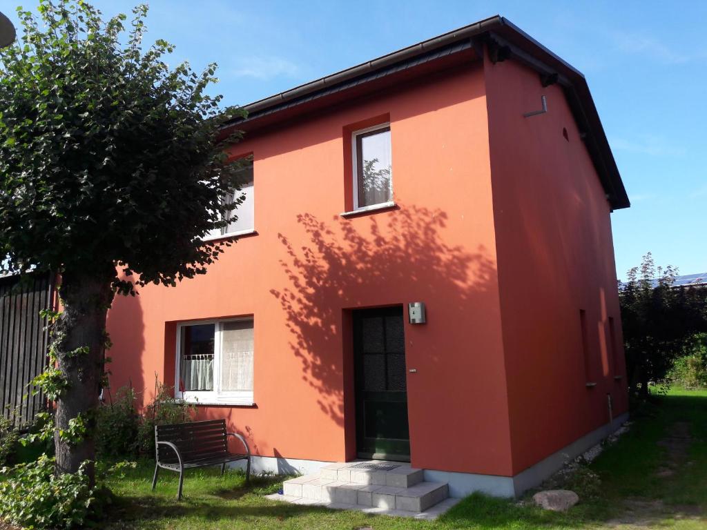 a red house with a tree in front of it at Kanuhof Spandowerhagen in Kröslin