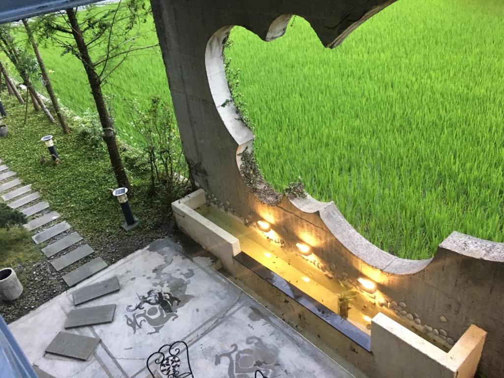 a view of a field from a window with lights at 建築師湧泉泡湯會館 in Dongshan