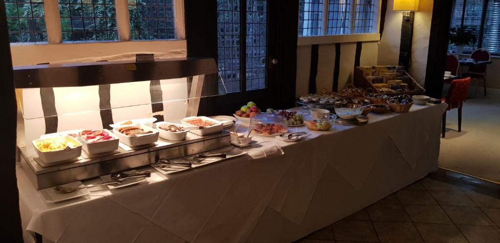 a buffet line with many dishes of food on it at The Tudor Hotel in Harrow