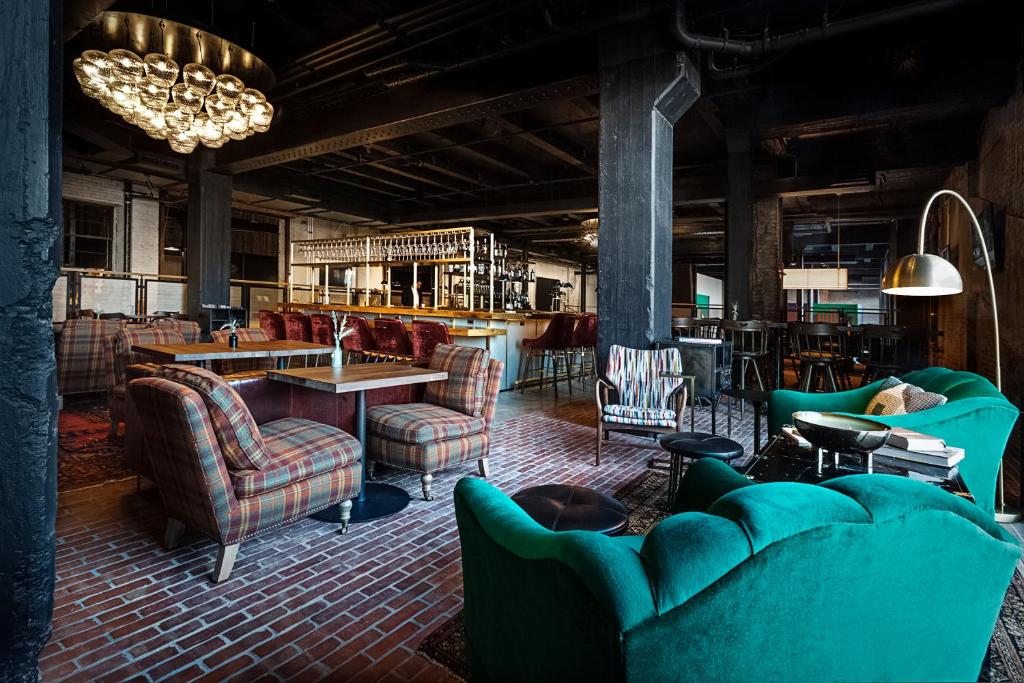 a large room with couches and tables and chairs at Crossroads Hotel in Kansas City