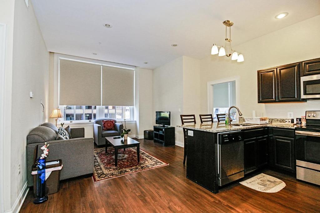 a kitchen and living room with a couch and a table at Chase at Lexington ST Free indoor parking Convention Center in Baltimore