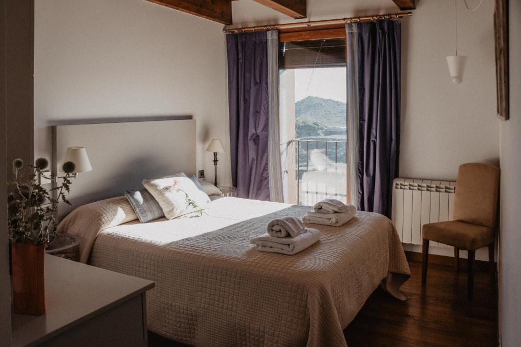 a bedroom with a bed with two towels on it at La Casa del Muro in Sos del Rey Católico